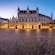 The gothic style facade of the Chapel of the Holy Blood in Bruges lit up at night.